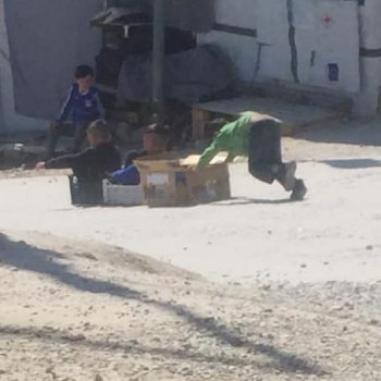 Kinder in Moria spielen mit selbstgebauten Schlitten